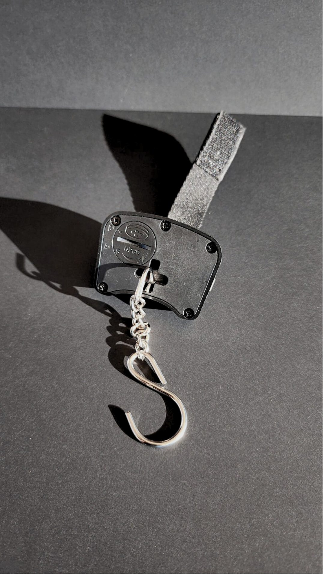 Metallic hook on a dark gray background